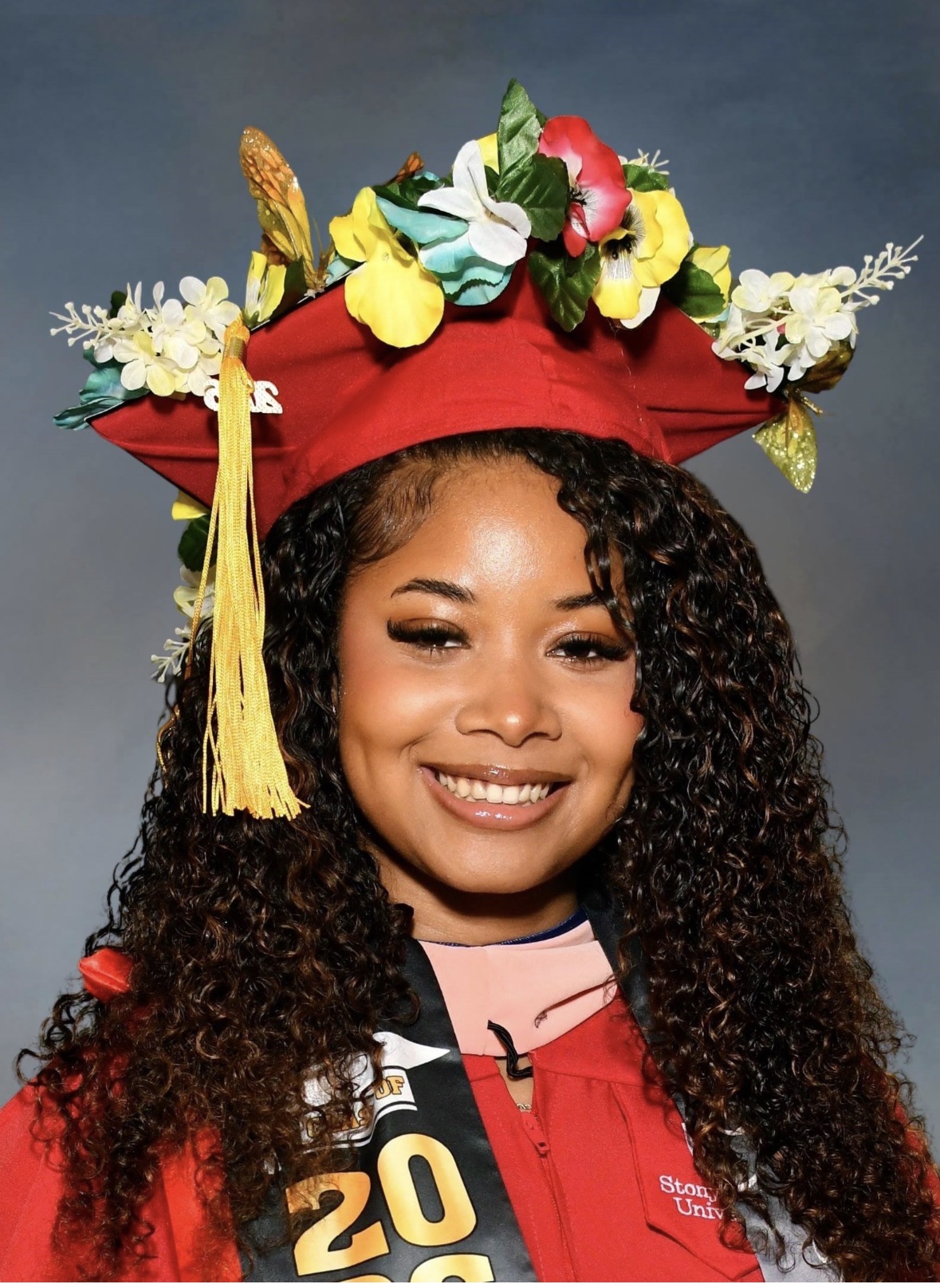 Jonell Ashby Headshot in Red Graduation Cap and Gown